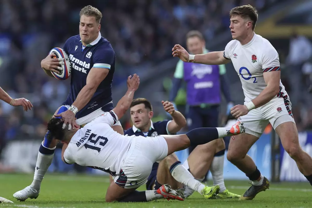 Scotland's Duhan van der Merwe, left, holds off England's Marcus Smith during the Six Nations rugby union match between England and Scotland at Twickenham in London, Saturday, Feb. 22, 2025. (AP Photo/Ian Walton)