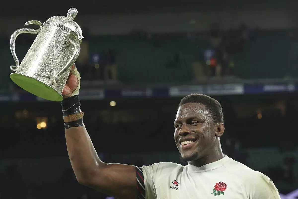 England's Maro Itoje celebrates with the Calcutta Cup after winning the Six Nations rugby union match between England and Scotland at Twickenham in London, Saturday, Feb. 22, 2025. (AP Photo/Ian Walton)