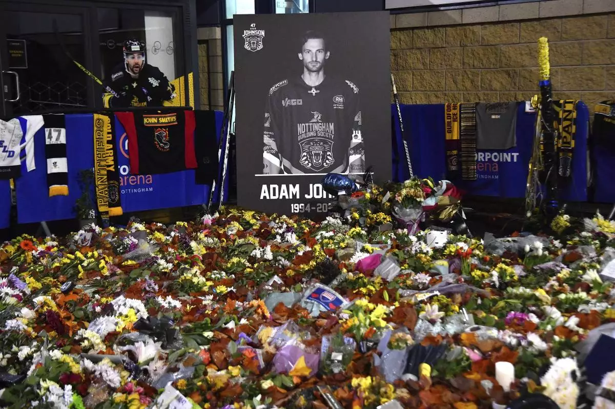 FILE - Floral tributes for Nottingham Panthers player Adam Johnson, who died from a skate cut to the neck, rest outside the Motorpoint Arena before a memorial ice hockey game between the Panthers and the Manchester Storm in Nottingham, England, Nov. 18, 2023. (AP Photo/Rui Vieira, File)