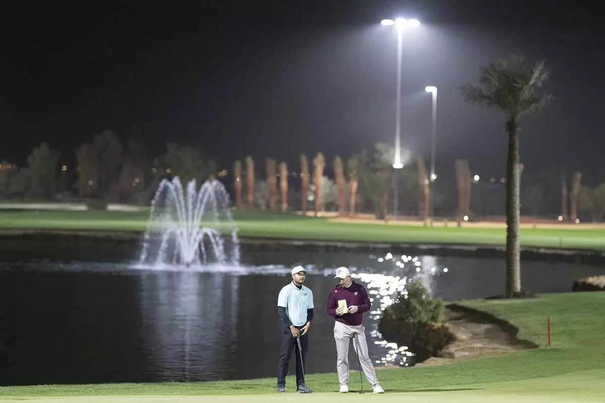 Sebastián Muñoz of Torque GC and Lucas Herbert of Ripper GC talk on the 13th green during the final round of the LIV Golf tournament at Riyadh Golf Club, Saturday, Feb. 8, 2025 in Riyadh, Saudi Arabia. (Photo by Charles Laberge/LIV Golf via AP)