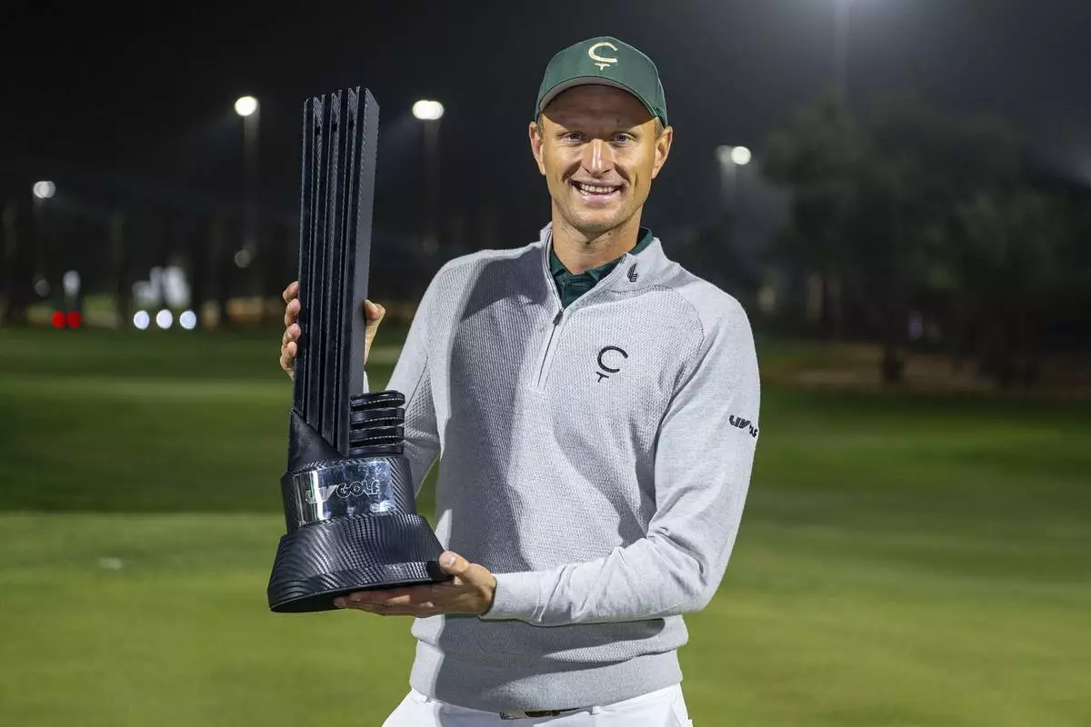 First place individual champion Adrian Meronk of Cleeks GC poses with the trophy on the 18th green after the final round of the LIV Golf tournament at Riyadh Golf Club, Saturday, Feb. 8, 2025 in Riyadh, Saudi Arabia. (Photo by Montana Pritchard/LIV Golf via AP)