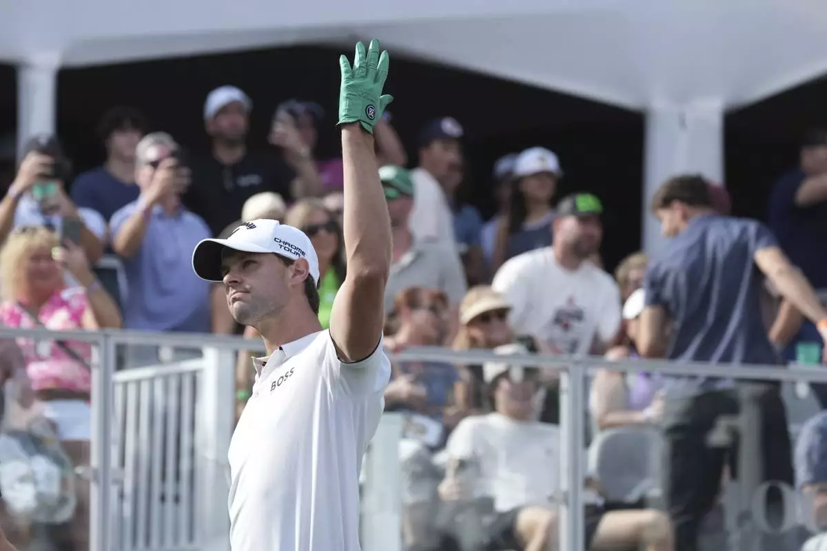 Thomas Detry, of Belgium, waves to the cheering crowd after hitting his tee shot close to the pin on the 16th hole during the final round of the Phoenix Open golf tournament at TPC Scottsdale, Sunday, Feb. 9, 2025, in Scottsdale, Ariz. (AP Photo/Ross D. Franklin)