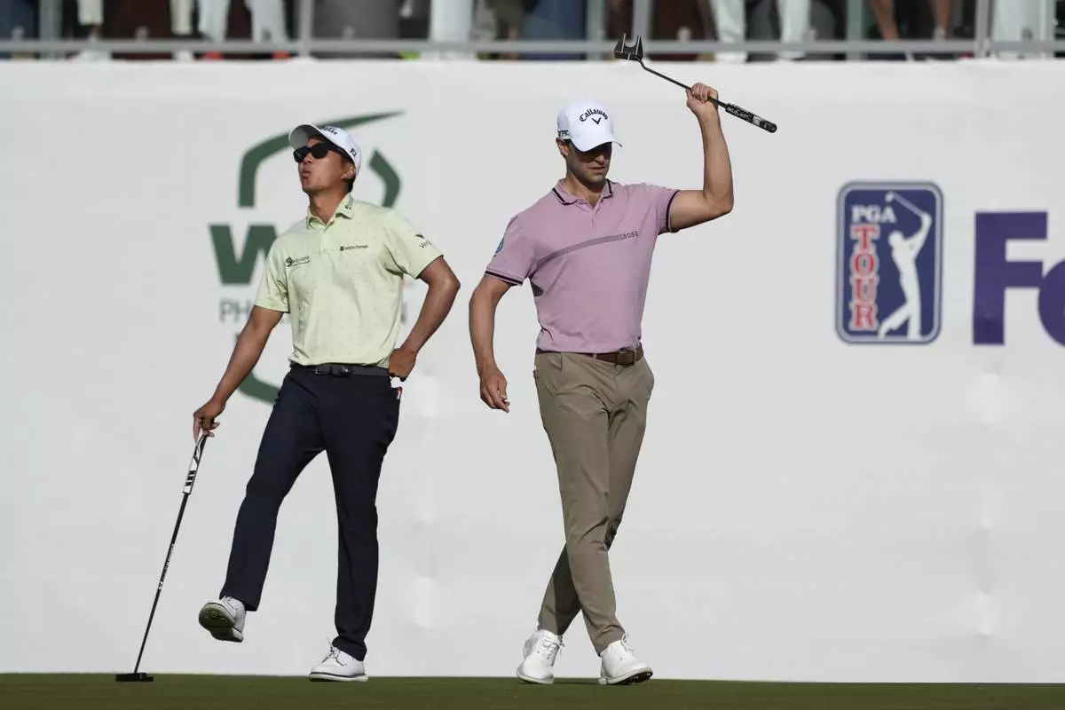 Thomas Detry, right, of Belgium, and Michael Kim, left, react to Detry's missed birdie putt on the 16th hole during the third round of the Phoenix Open golf tournament at TPC Scottsdale Saturday, Feb. 8, 2025, in Scottsdale, Ariz. (AP Photo/Ross D. Franklin)