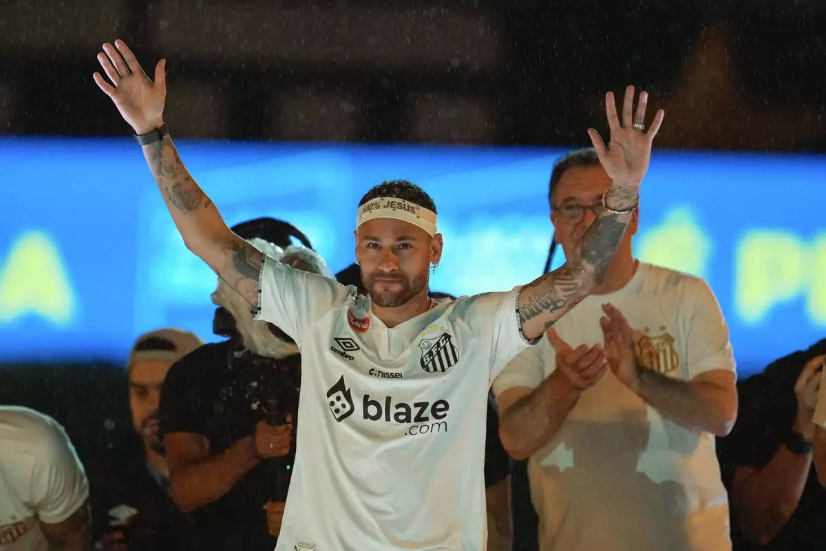 Brazilian soccer player Neymar waves to fans during his presentation ceremony after signing a six-month contract with Santos FC at Vila Belmiro Stadium in Santos, Brazil, Friday, Jan. 31, 2025. (AP Photo/Andre Penner)