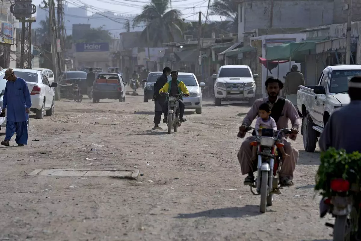 Vehicles and motorcyclists drive on a dusty road in the coastal city of Gwadar, in the southwest Pakistani province of Balochistan, Jan. 13, 2025. (AP Photo/Anjum Naveed)