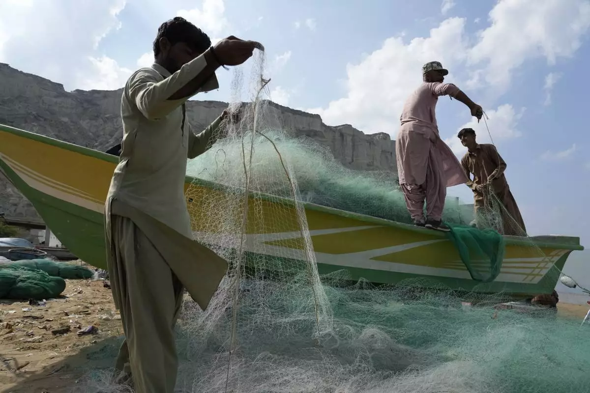 Fishermen repair fishing net in the coastal city of Gwadar, in the southwest Pakistani province of Balochistan, Jan. 13, 2025. (AP Photo/Anjum Naveed)