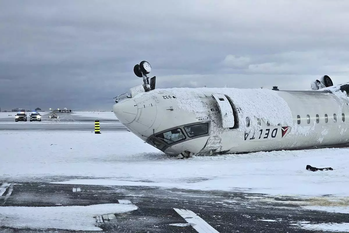 CORRECTS SOURCE TO TRANSPORTATION SAFETY BOARD OF CANADA INSTEAD OF NATIONAL TRANSPORTATION SAFETY BOARD - In this image provided by the Transportation Safety Board of Canada, the wreckage of a Delta Air Lines jet rests upside down, Tuesday, Feb. 18, 2025, after it burst into flames and flipped upside down as it tried to land on Feb. 17, at Toronto Pearson International Airport in Mississauga, Ontario. (Transportation Safety Board of Canada via AP)