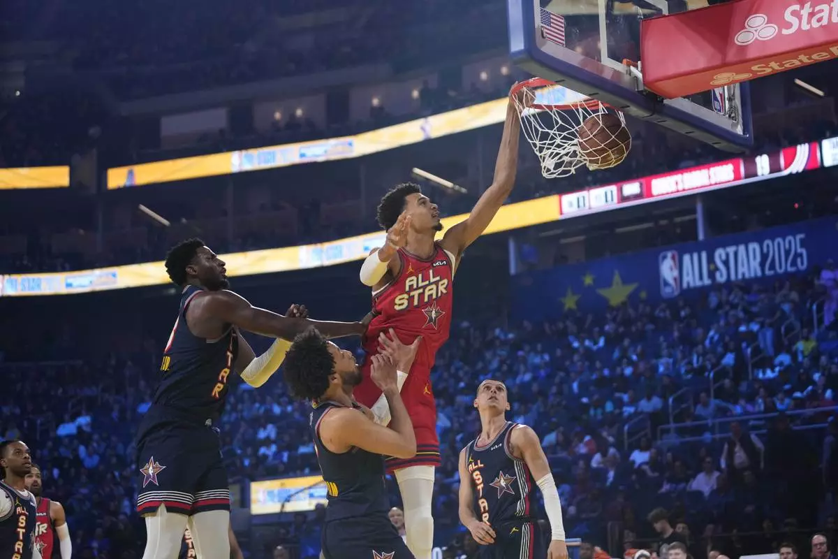 San Antonio Spurs center Victor Wembanyama dunks over Detroit Pistons guard Cade Cunningham during the NBA All-Star basketball game Sunday, Feb. 16, 2025, in San Francisco. (AP Photo/Godofredo A. Vásquez)