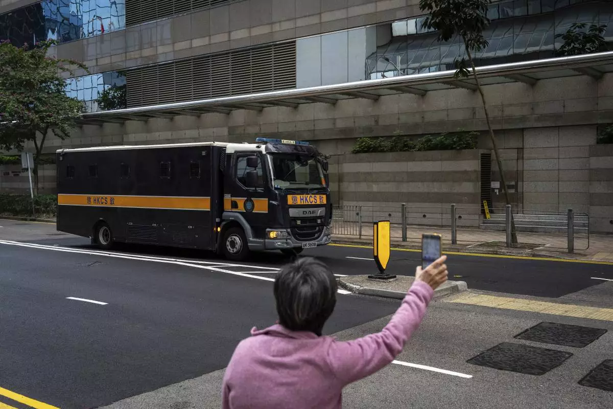 CORRECTS THE YEAR - A supporter waves hand to a Correctional Services prison van as it arrives at the District Court ahead of the sentencing on a riot case involving a former pro-democracy lawmaker Lam Cheuk-ting in Wan Chai, Hong Kong on Thursday, Feb. 27, 2025. (AP Photo/Chan Long Hei)