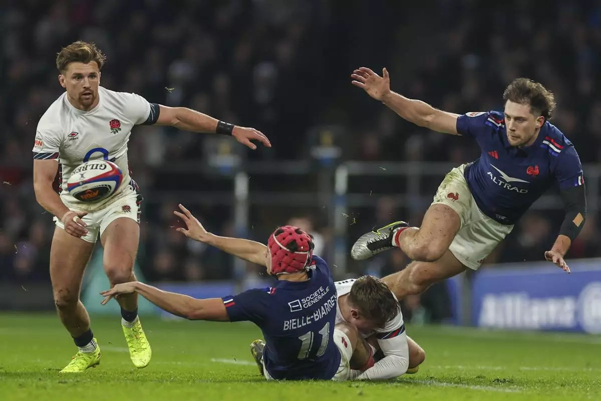 France's Louis Bielle-Biarrey offloads in the tackle during the Six Nations rugby union match between England and France at Twickenham in London, Saturday, Feb. 8, 2025. (AP Photo/Ian Walton)