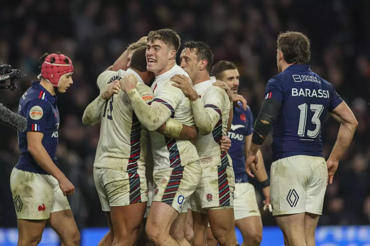 England's Tommy Freeman, center, celebrates after Elliot Daly scored a try during the Six Nations rugby union match between England and France at Twickenham in London, Saturday, Feb. 8, 2025. (AP Photo/Ian Walton)