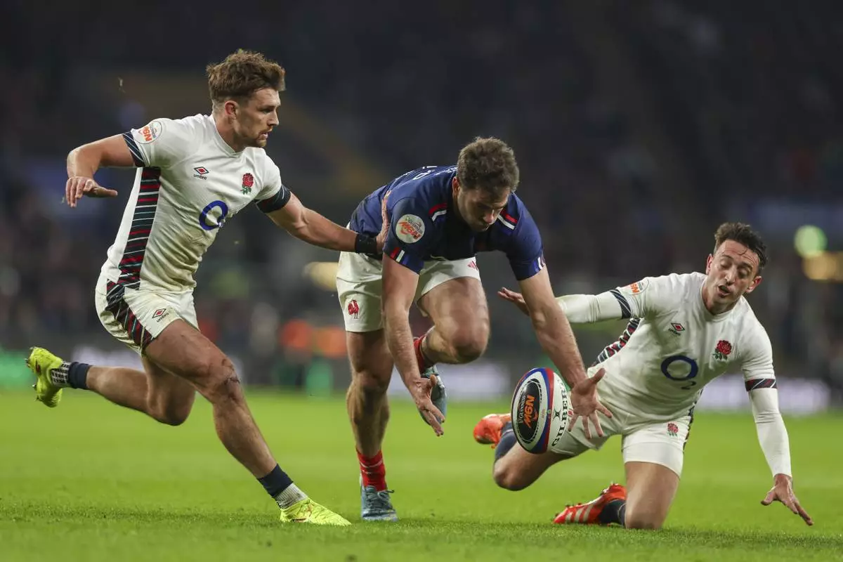 France's Damian Penaud, center, drops the ball challenged by England's Henry Slade, left, and Alex Mitchell during the Six Nations rugby union match between England and France at Twickenham in London, Saturday, Feb. 8, 2025. (AP Photo/Ian Walton)