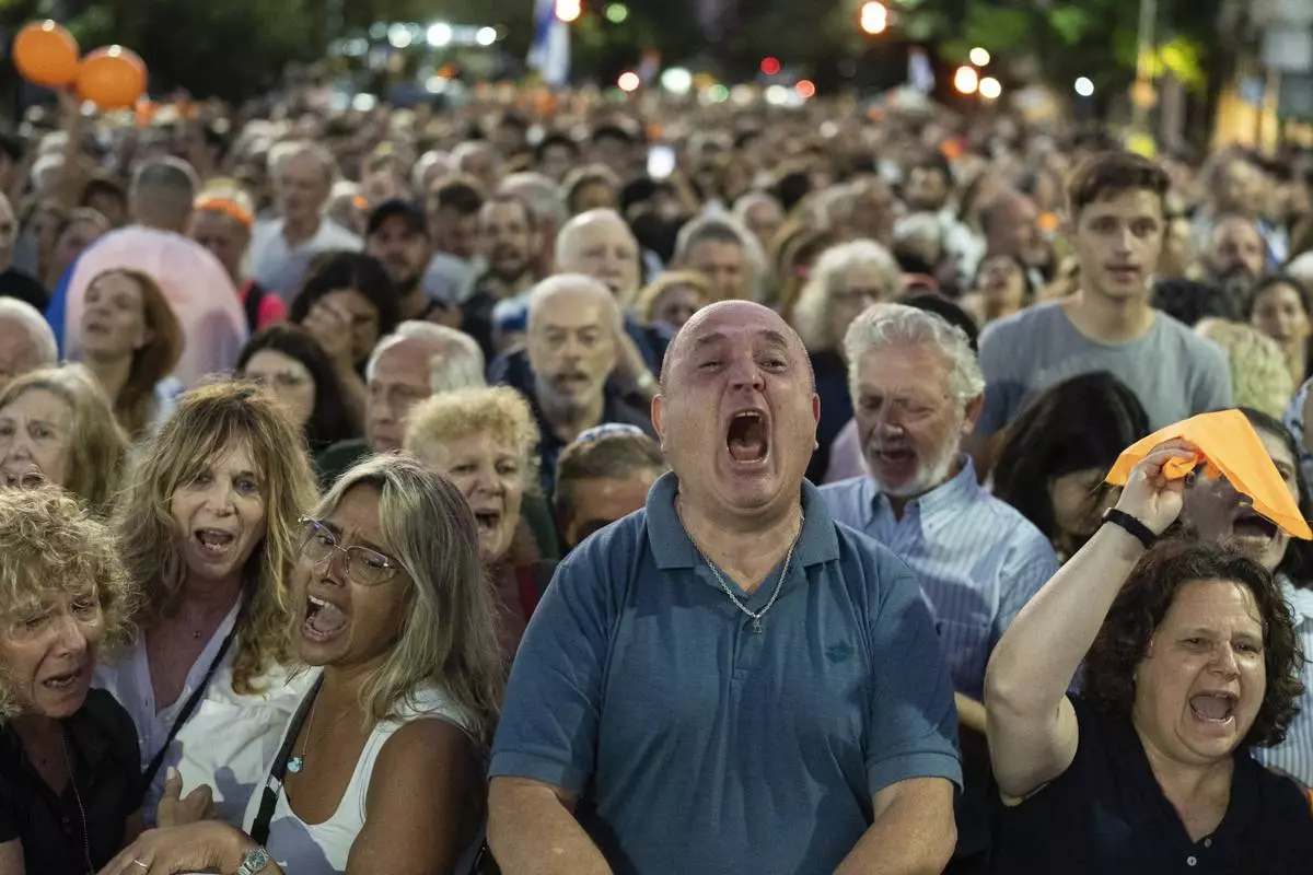 Members of the Jewish community sing the Israeli anthem while gathering in support of relatives of the hostages and victims of the October 7 massacre and to demand Hamas release the remaining hostages, in Buenos Aires, Argentina, Monday, Feb. 24, 2025. (AP Photo/Rodrigo Abd)