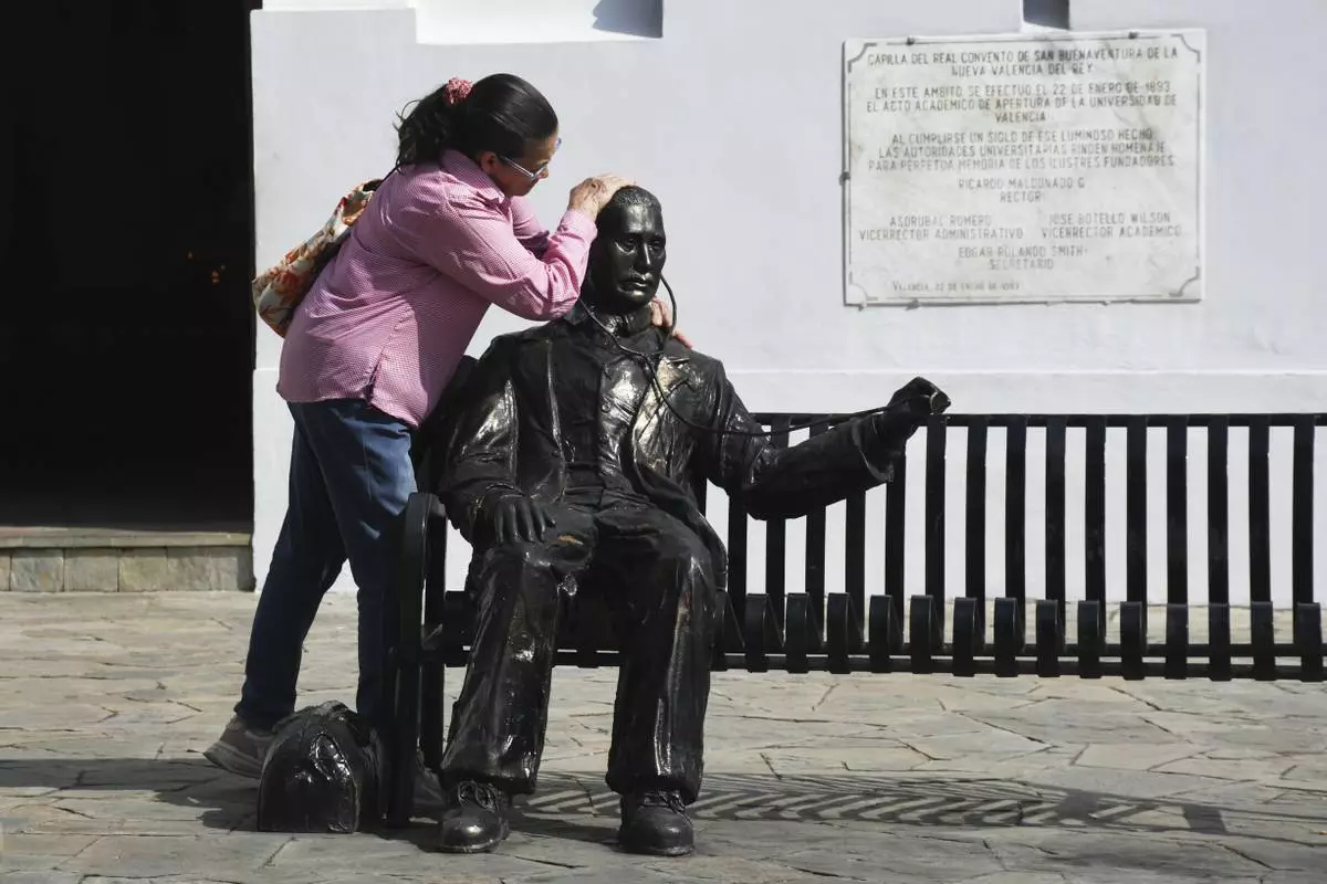 A woman embraces a statue of José Gregorio Hernandez, the physician known as the "doctor of the poor", in Valencia, Venezuela, Tuesday, Feb. 25, 2025. Pope Francis on Tuesday approved a decree to canonize Hernandez, making him Venezuela's first saint. (AP Photo/Jacinto Oliveros)