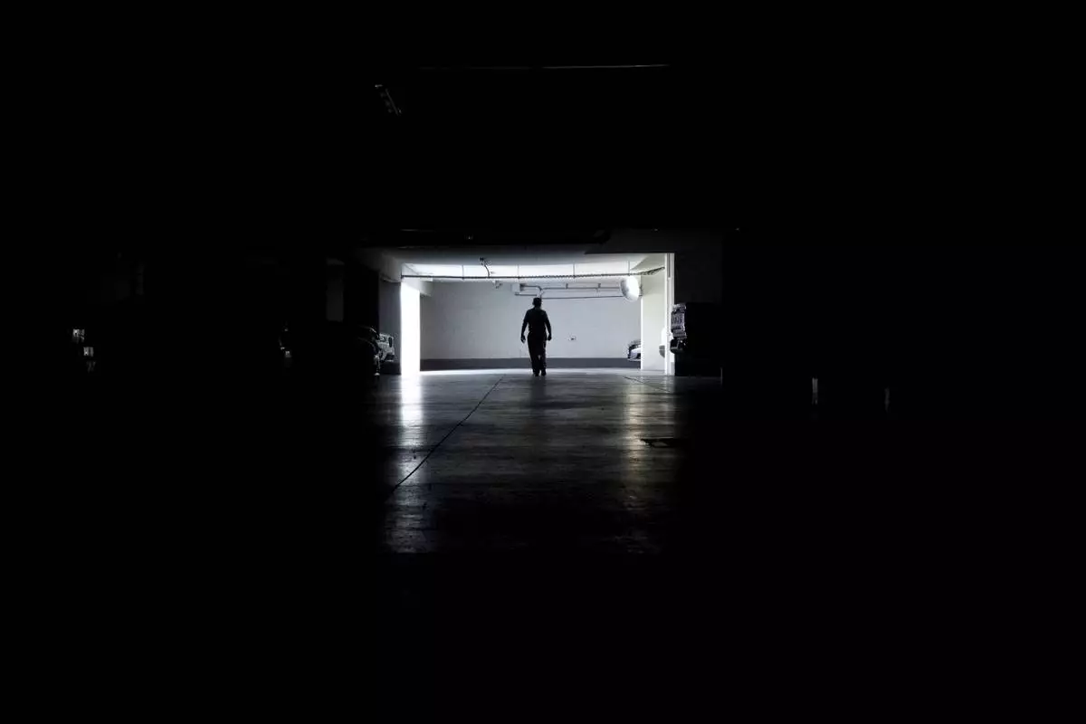 A man walks in a parking garage during a power outage, in Santiago, Chile, Tuesday, Feb. 25, 2025. (AP Photo/Matias Basualdo)