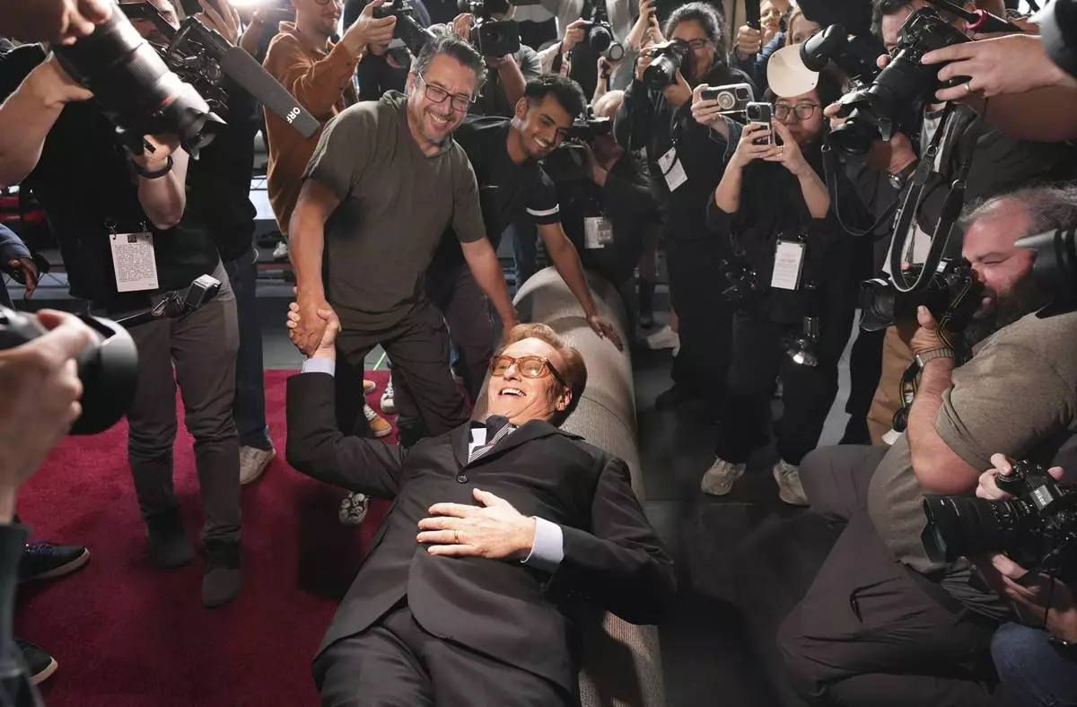 Conan O'Brien, host of Sunday's 97th Academy Awards, poses atop the red carpet during the annual red carpet roll out at the Dolby Theatre on Wednesday, Feb. 26, 2025, in Los Angeles. (AP Photo/Chris Pizzello)