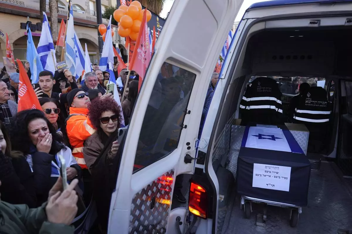 Mourners gather around the car carrying the coffins of slain hostages Shiri Bibas and her two children, Ariel and Kfir, during their funeral procession in Rishon Lezion, Israel, Wednesday, Feb. 26, 2025. (AP Photo/Ariel Schalit)