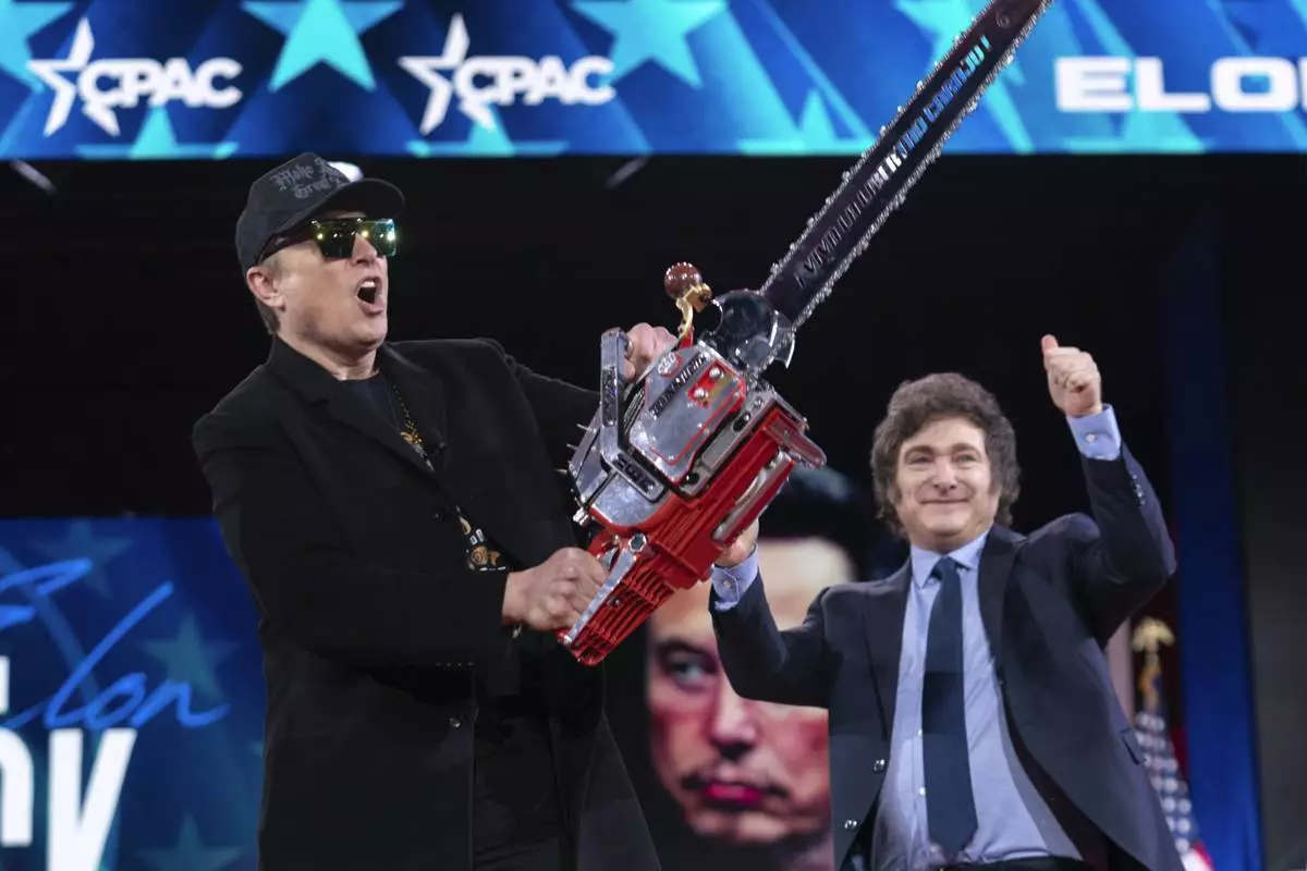 Elon Musk, left, receives a chainsaw from Argentina's President Javier Milei as they arrive speaks at the Conservative Political Action Conference, CPAC, at the Gaylord National Resort &amp; Convention Center, Thursday, Feb. 20, 2025, in Oxon Hill, Md. (AP Photo/Jose Luis Magana)