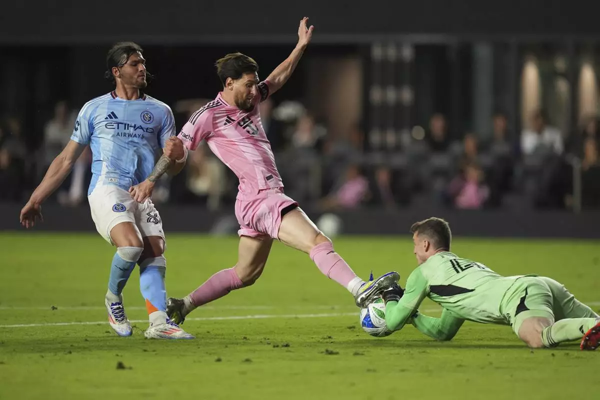 CORRECTS ID TO JUSTIN HAAK NOT ANDRES PEREA - New York City FC goalkeeper Matt Freese stops a scoring attempt by Inter Miami forward Lionel Messi, as New York City FC midfielder Justin Haak (80) looks on, during the second half of an MLS soccer match, Saturday, Feb. 22, 2025, in Fort Lauderdale, Fla. (AP Photo/Rebecca Blackwell)