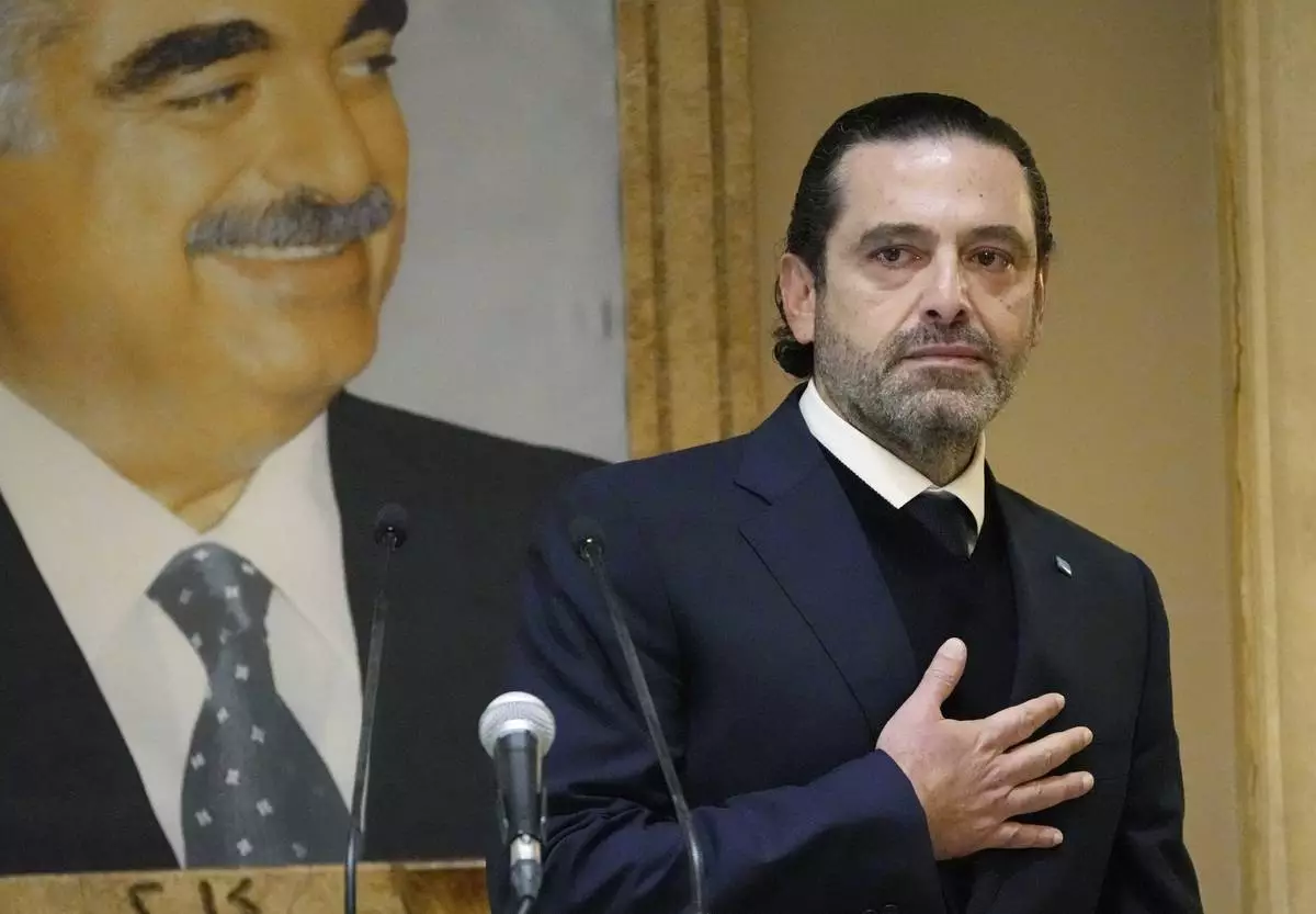 FILE - Former Lebanese Prime Minister Saad Hariri, gestures in front of a picture of his late father and former Prime Minister of Lebanon Rafic Hariri at his house in downtown Beirut, Lebanon, on Jan. 24, 2022. (AP Photo/Hussein Malla, File)