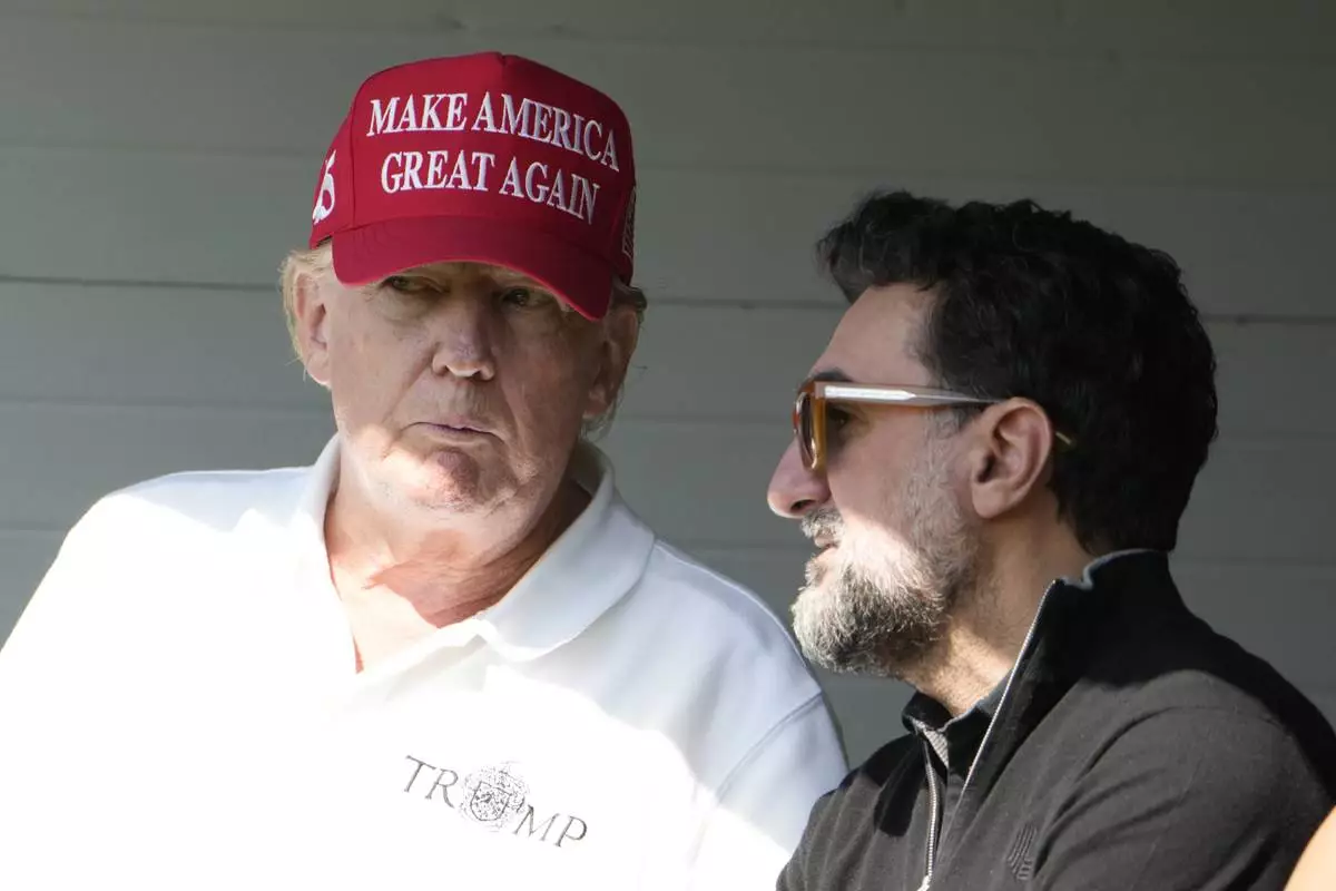 FILE - Former President Donald Trump talks with Yasir Al-Rumayyan, during the first round of the LIV Golf Tournament at Trump National Golf Club, in Sterling, Va., May 26, 2023. (AP Photo/Alex Brandon, File)