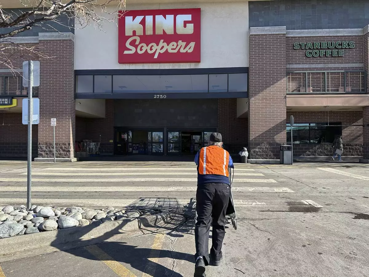 FILE - An employee pushes a string of shopping carts back into a King Soopers grocery store for customers' use, Jan. 27, 2025, in southeast Denver. (AP Photo/David Zalubowski, File)
