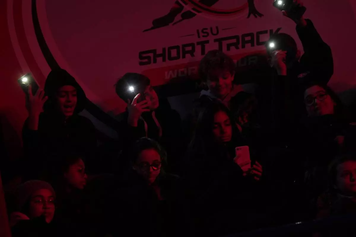 Spectators light smartphone torches during preliminaries round of the ISU Short Track World Tour, Olympics Milano-Cortina 2026 test event, in Milan, Italy, Friday, Feb. 14, 2025. (AP Photo/Luca Bruno)