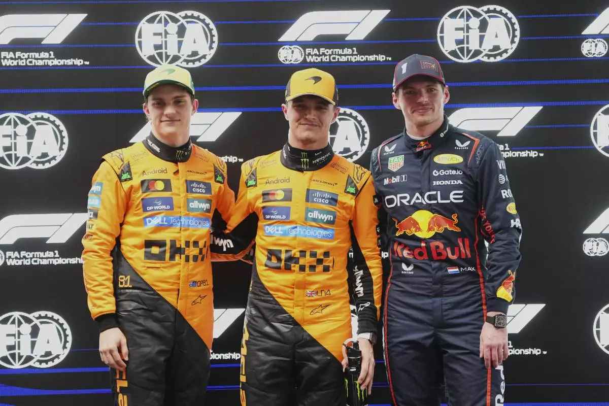McLaren driver Lando Norris, centre of Britain poses after taking pole position with second placed teammate Oscar Piastri, left, of Australia and third placed Red Bull driver Max Verstappen of the Netherlands at the Australian Formula One Grand Prix at Albert Park, in Melbourne, Australia, Saturday, March 15, 2025. (AP Photo/Scott Barbour)