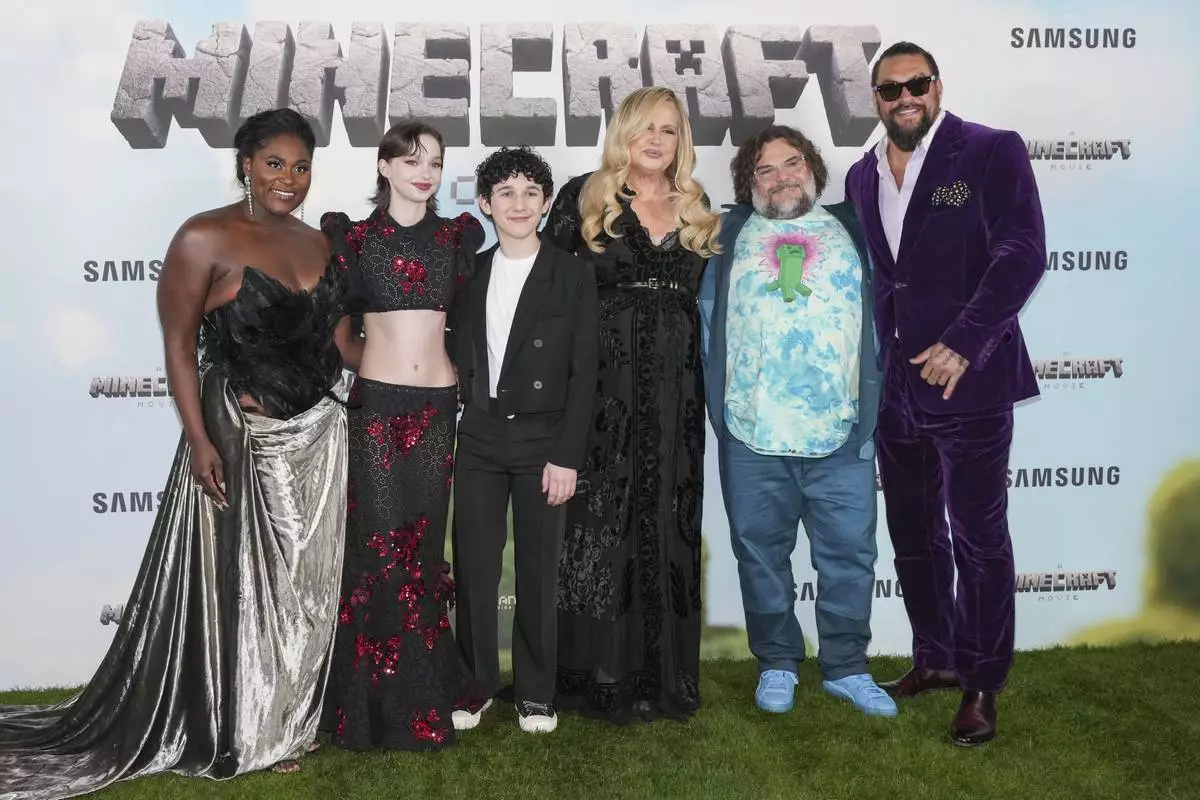 Danielle Brooks, from left, Emma Myers, Sebastian Hansen, Jennifer Coolidge, Jack Black and Jason Momoa pose for photographers upon arrival at the World premiere of A Minecraft Movie on Sunday, March 30, 2025, in London. (Photo by Scott A Garfitt/Invision/AP)