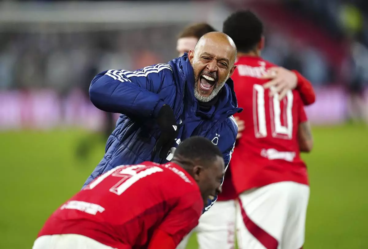 Nottingham Forest manager Nuno Espirito Santo, top, celebrates after winning the penalty shootout during the English FA Cup fifth soccer round match between Nottingham Forest and Ipswich Town at the City Ground, Nottingham, England, Monday, March 3, 2025. (Mike Egerton/PA via AP)