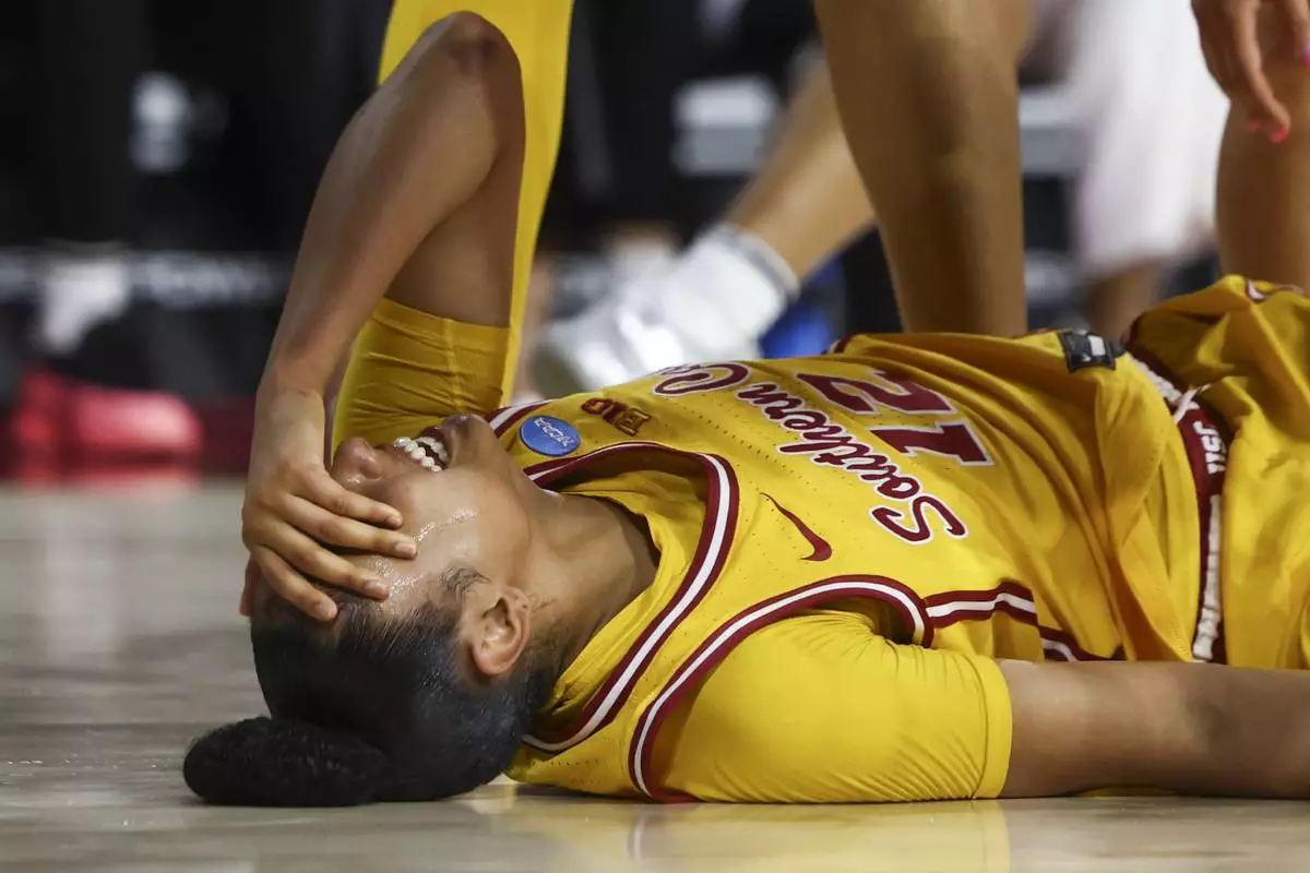 Southern California guard JuJu Watkins (12) reacts on the floor after an injury during the first half against Mississippi State in the second round of the NCAA college basketball tournament Monday, March 24, 2025, in Los Angeles. (AP Photo/Jessie Alcheh)