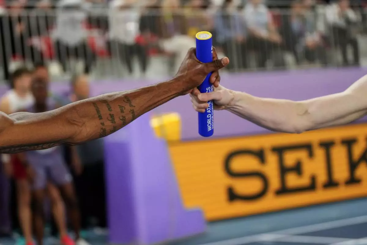 Jacory Patterson, left, of the United States, receives the baton from teammate Brian Faust, during the World Athletics Indoor Championships in Nanjing, China, Sunday, March 23, 2025.(AP Photo/Dar Yasin)