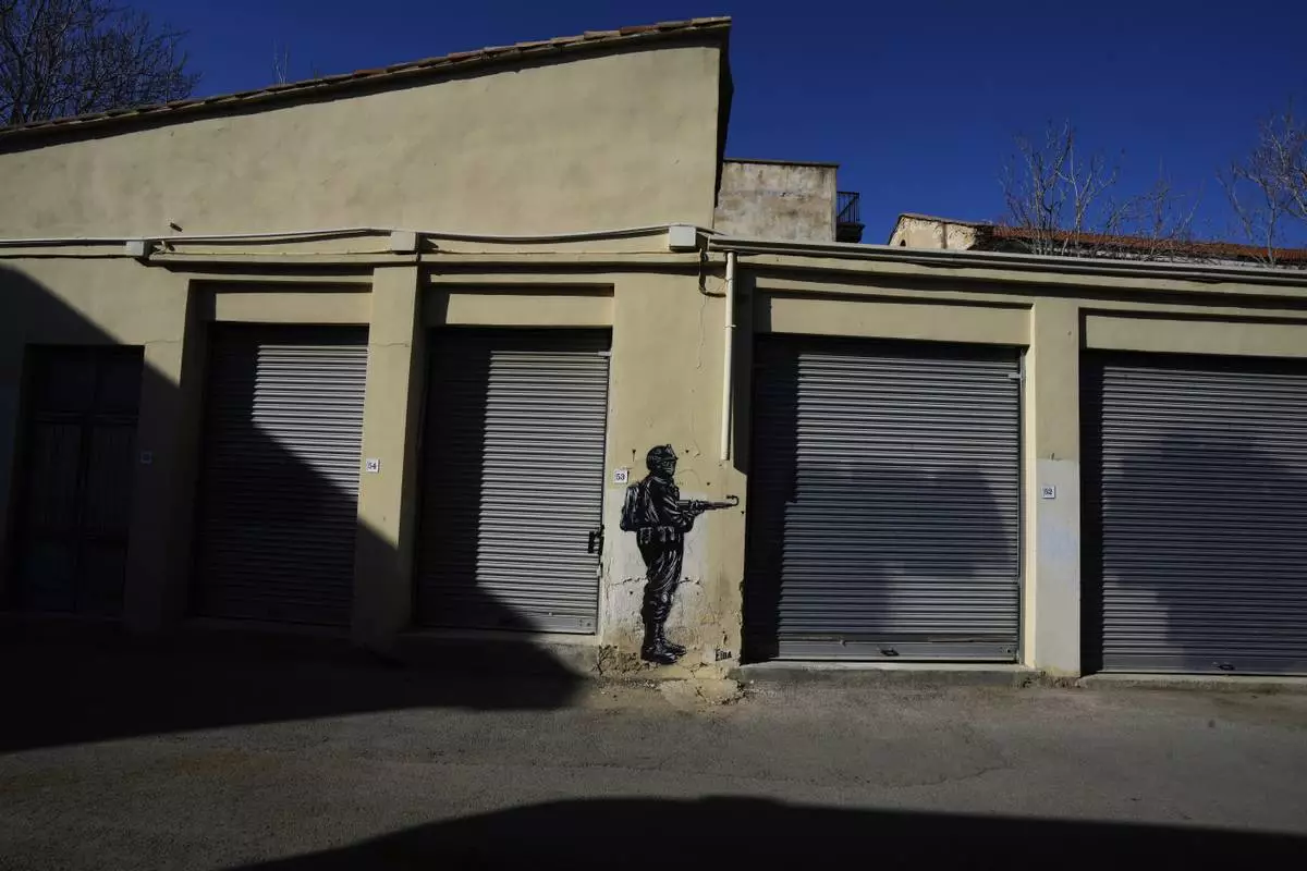 A painting showing a soldier is seen across the U.N buffer zone in divided capital Nicosia, Cyprus, Tuesday, March 18, 2025. (AP Photo/Petros Karadjias)