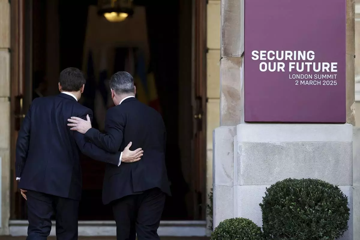 Britain's Prime Minister Keir Starmer, right, welcomes French President Emmanuel Macron to the European leaders' summit to discuss Ukraine, at Lancaster House, London, Sunday March 2, 2025. (Toby Melville/Pool via AP)