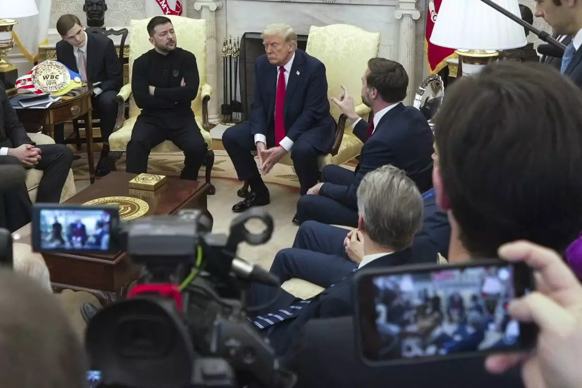 Vice President JD Vance, right, speaks with Ukrainian President Volodymyr Zelenskyy, left, as President Donald Trump, center, listens in the Oval Office at the White House, Friday, Feb. 28, 2025, in Washington. (AP Photo/ Mystyslav Chernov)