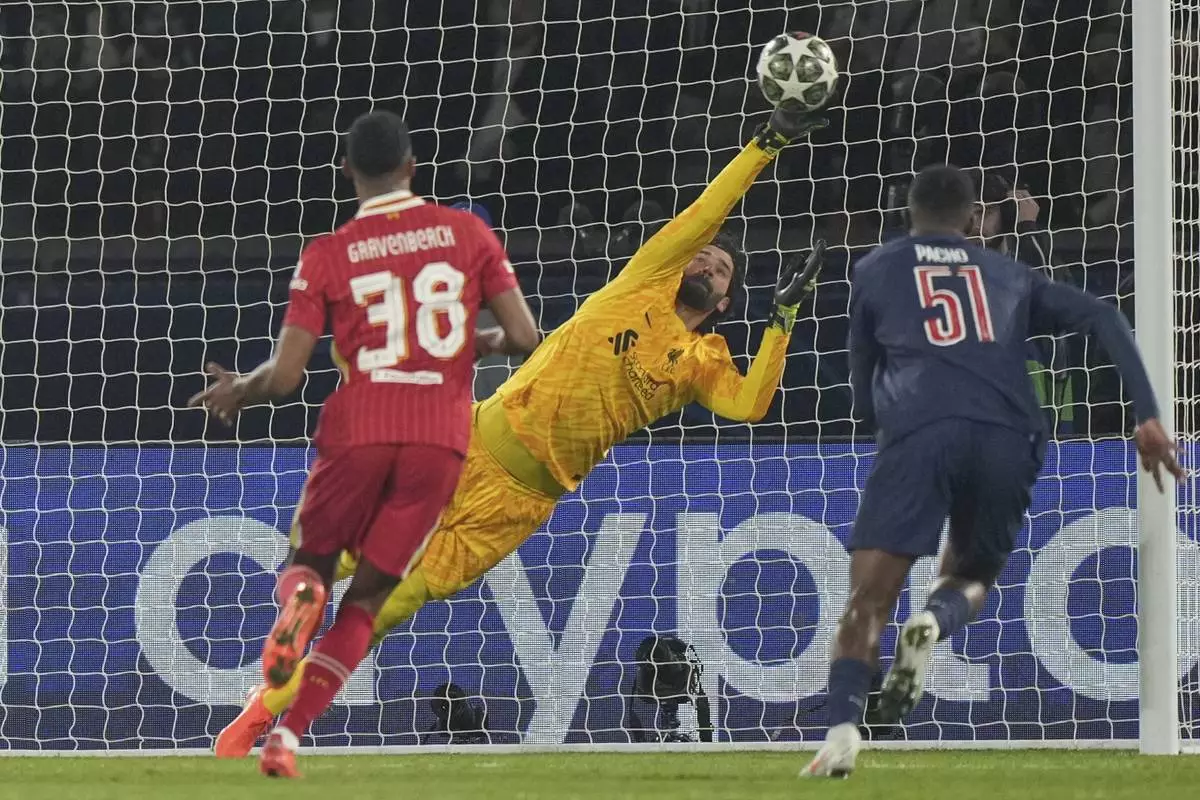 Liverpool's goalkeeper Alisson makes a save during the Champions League round of 16 first leg soccer match between Paris Saint-Germain and Liverpool at the Parc des Princes in Paris, Wednesday, March 5, 2025. (AP Photo/Aurelien Morissard)