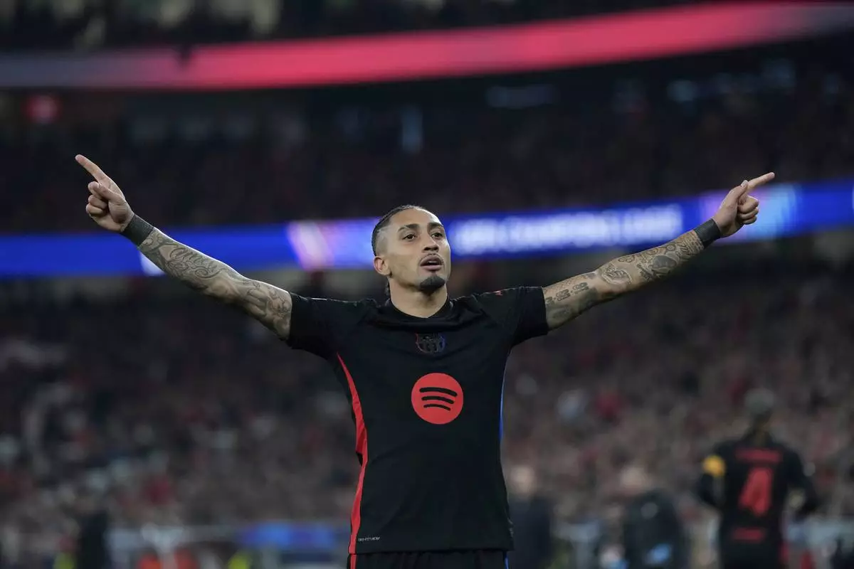 Barcelona's Raphinha celebrates after scoring his side's opening goal during the Champions League round of 16 first leg soccer match between SL Benfica and FC Barcelona at the Luz stadium in Lisbon, Wednesday, March 5, 2025. (AP Photo/Armando Franca)