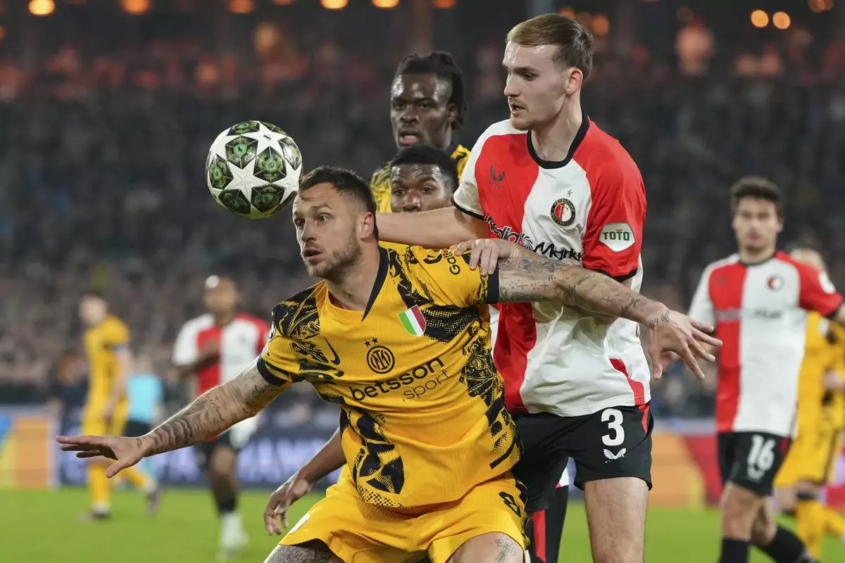 Inter Milan's Marko Arnautovic, front , and Feyenoord's Thomas Beelen fight for the ball during the Champions League round of 16 first leg soccer match between Feyenoord and Inter Milan in Rotterdam, Netherlands, Wednesday, March 5, 2025. (AP Photo/Peter Dejong)
