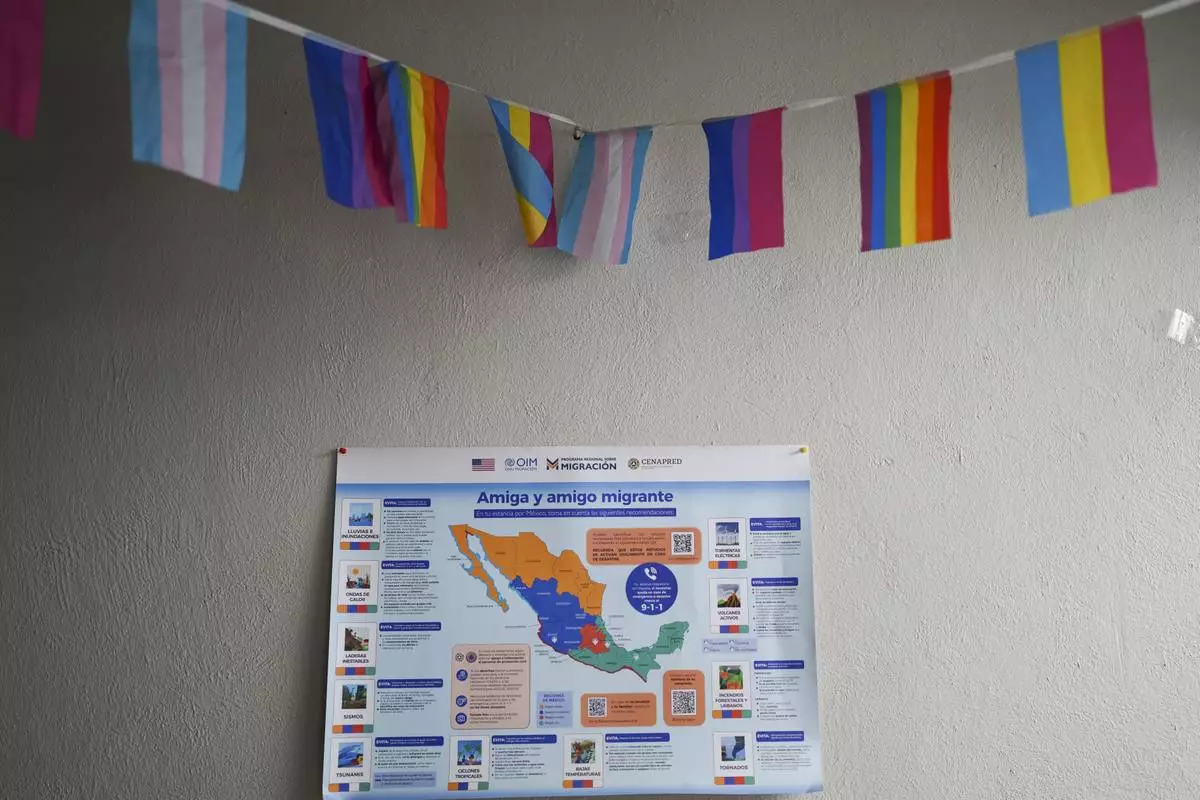 Pride flags and a map of Mexico adorn a wall in a room at Casa Frida, a shelter that supports LGBTQ+ migrants, in Mexico City, Tuesday, Feb. 18, 2025. (AP Photo/Eduardo Verdugo)