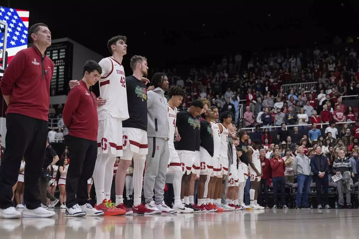 Stanford forward Maxime Raynaud (42) and teammates listen to the national anthem before an NCAA college basketball game against California, Saturday, Feb. 22, 2025, in Stanford, Calif. (AP Photo/Godofredo A. Vásquez)