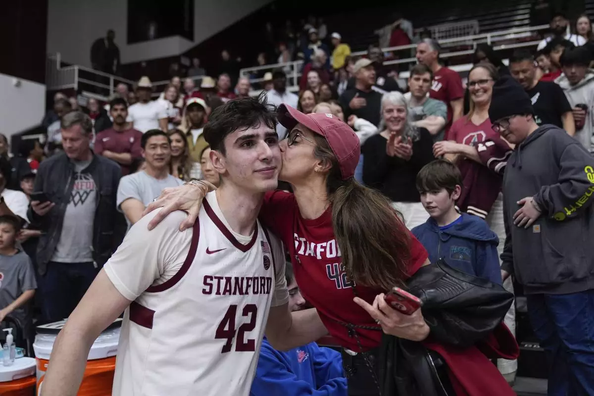 Stanford forward Maxime Raynaud (42) is kissed by his mother Vanessa Raynaud after the team's victory against California in an NCAA college basketball game Saturday, Feb. 22, 2025, in Stanford, Calif. (AP Photo/Godofredo A. Vásquez)