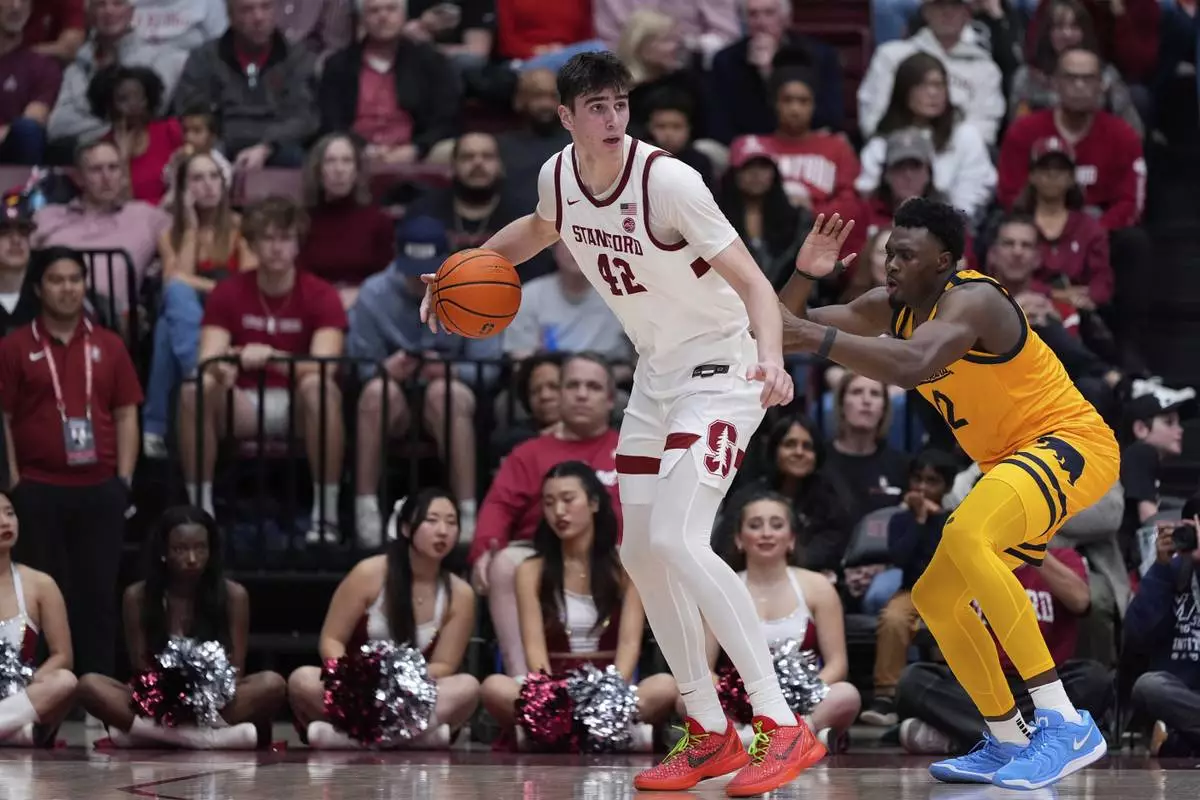 Stanford forward Maxime Raynaud (42) looks for an open teammate while defended by California center Mady Sissoko, right, during the first half of an NCAA college basketball game Saturday, Feb. 22, 2025, in Stanford, Calif. (AP Photo/Godofredo A. Vásquez)