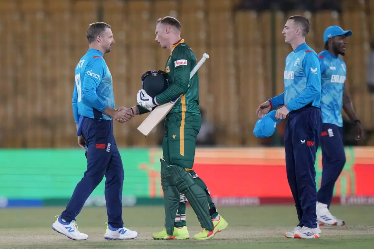 South Africa's Rassie van der Dussen, center, shakes hand with England's Jos Buttler, left, on the end of the ICC Champions Trophy cricket match between England and South Africa, in Karachi, Pakistan Saturday, March 1, 2025. (AP Photo/Anjum Naveed)