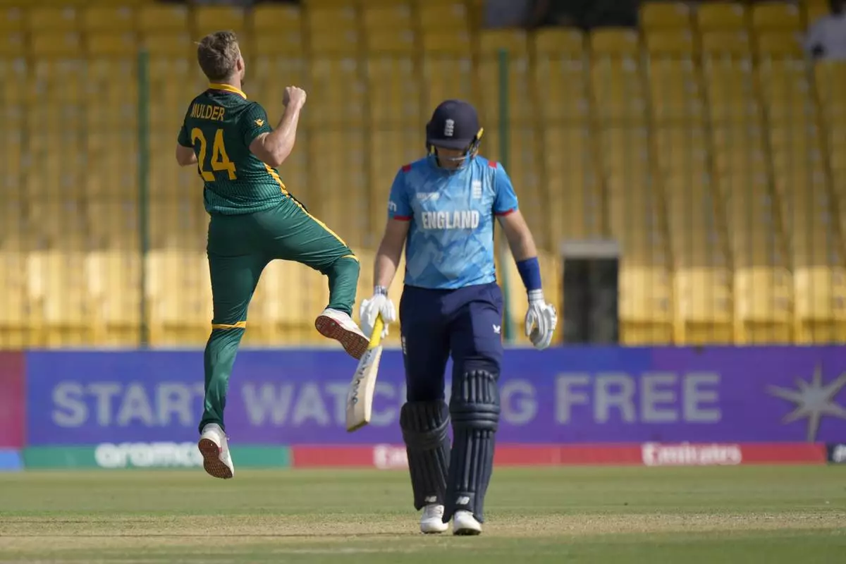 South Africa's Wiaan Mulder, left, celebrates after taking the wicket of England's Joe Root, right, during the ICC Champions Trophy cricket match between England and South Africa, in Karachi, Pakistan Saturday, March 1, 2025. (AP Photo/Anjum Naveed)