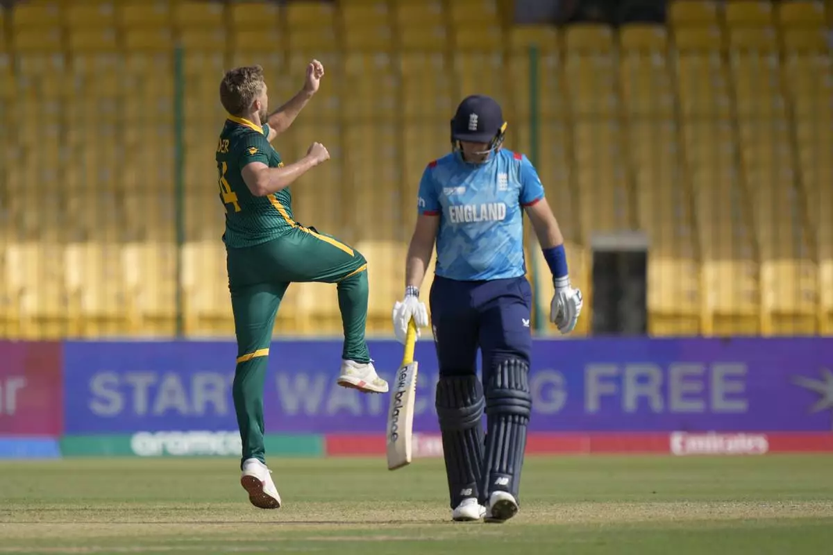 South Africa's Wiaan Mulder, left, celebrates after taking the wicket of England's Joe Root, right, during the ICC Champions Trophy cricket match between England and South Africa, in Karachi, Pakistan Saturday, March 1, 2025. (AP Photo/Anjum Naveed)