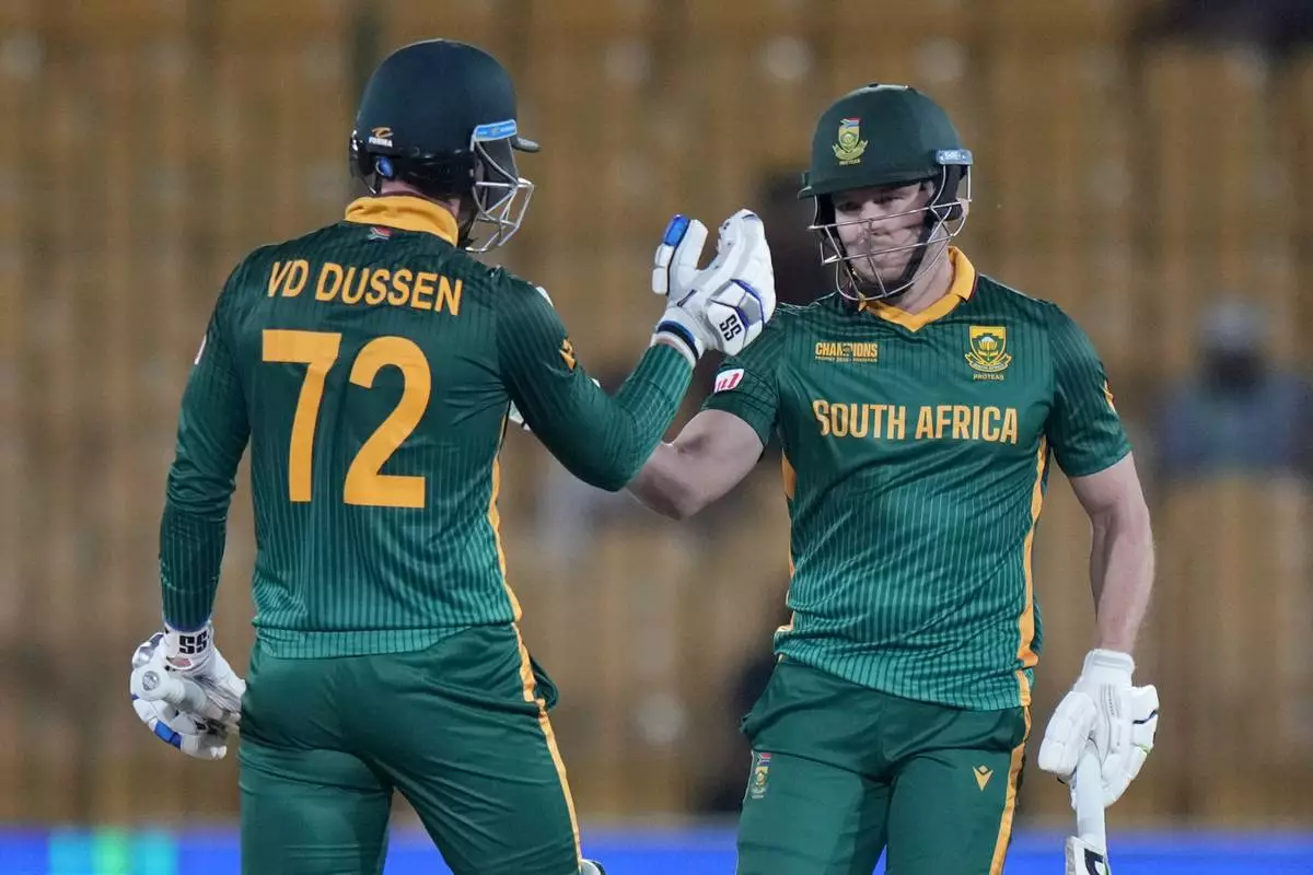 South Africa's David Miller, right, celebrates with Rassie van der Dussen after playing winning shot during the ICC Champions Trophy cricket match between England and South Africa, in Karachi, Pakistan Saturday, March 1, 2025. (AP Photo/Anjum Naveed)