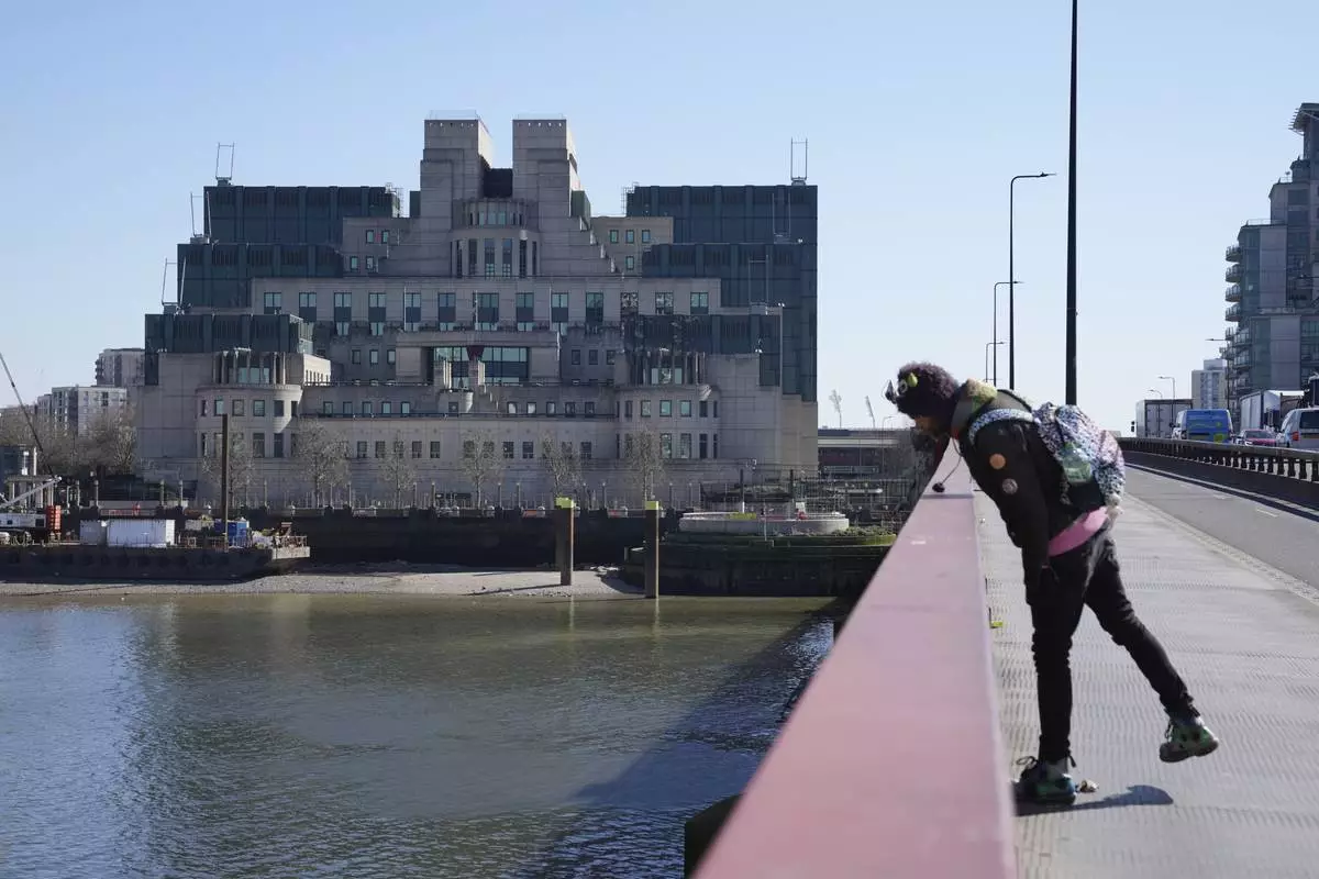 A man stands in front of the headquarters of the Secret Intelligence Service, MI6, in London, Tuesday, March 18, 2025. (AP Photo/Kin Cheung)
