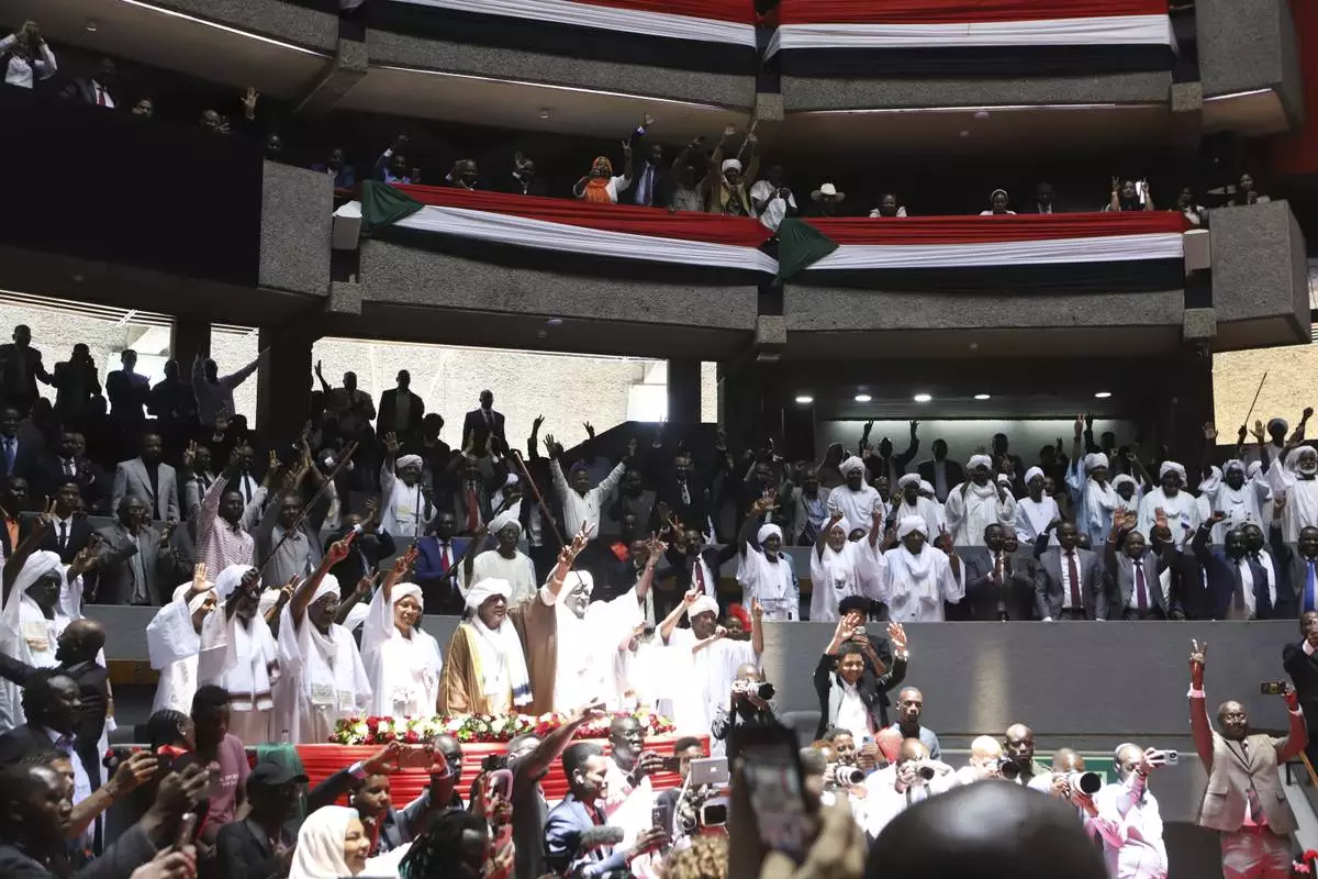 FILE - Delegates sing during a planned signing ceremony of the Sudan Founding Charter aimed at establishing a unity government involving leaders of political forces, armed groups, and the Rapid Support Forces (RSF) at the Kenyatta International Convention Centre (KICC) in Nairobi, on Feb. 18, 2025. (AP Photo/Andrew Kasuku)