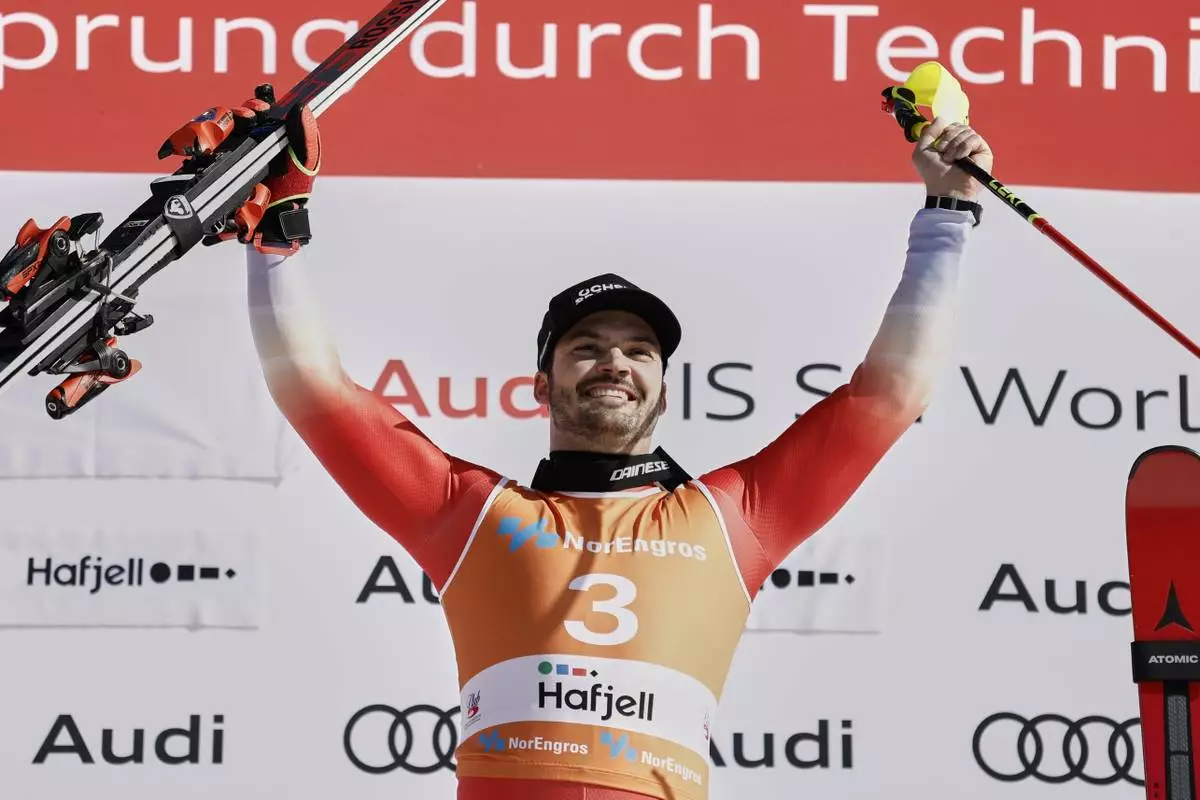 Switzerland's Loic Meillard celebrates on the podium after winning an alpine ski, men's World Cup slalom, in Hafjell, Norway, Sunday, March 16, 2025. (AP Photo/Gabriele Facciotti)