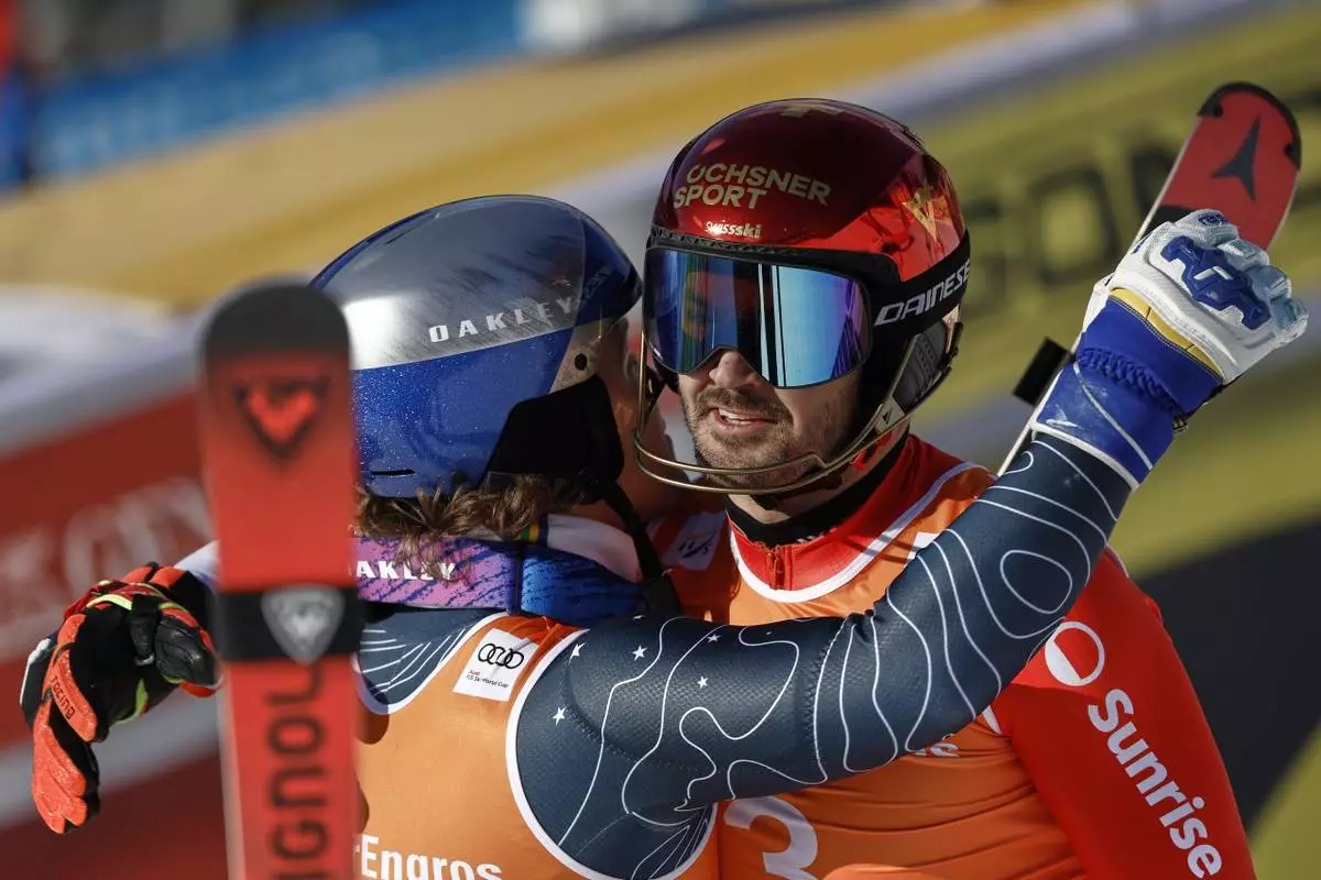 Switzerland's Loic Meillard, right, winner of an alpine ski, men's World Cup slalom, and third-placed Brazil's Lucas Pinheiro Braathen congratulate each other at the finish area, in Hafjell, Norway, Sunday, March 16, 2025. (AP Photo/Gabriele Facciotti)